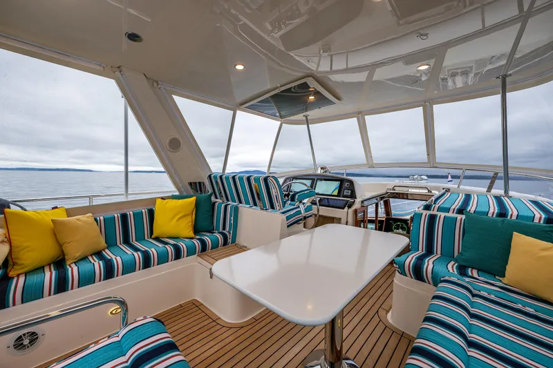 Slide: The Image of Luxurious 2026 Fleming 55 Pilothouse interior with striped seating, vibrant cushions, and panoramic ocean views. - 45