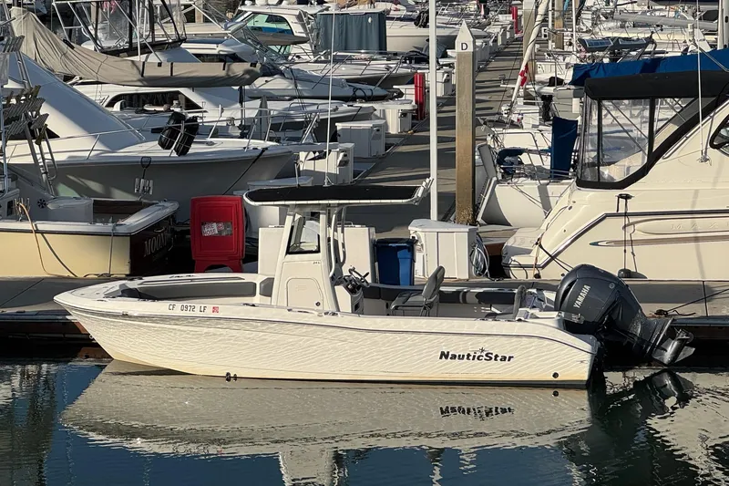 Slide: The Image of 2023 NauticStar 242L Offshore boat with Yamaha engine, docked in calm water. - 1