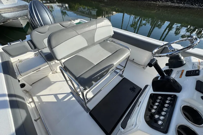 Slide: The Image of 2023 NauticStar 242L Offshore boat interior with seating and steering console. - 23