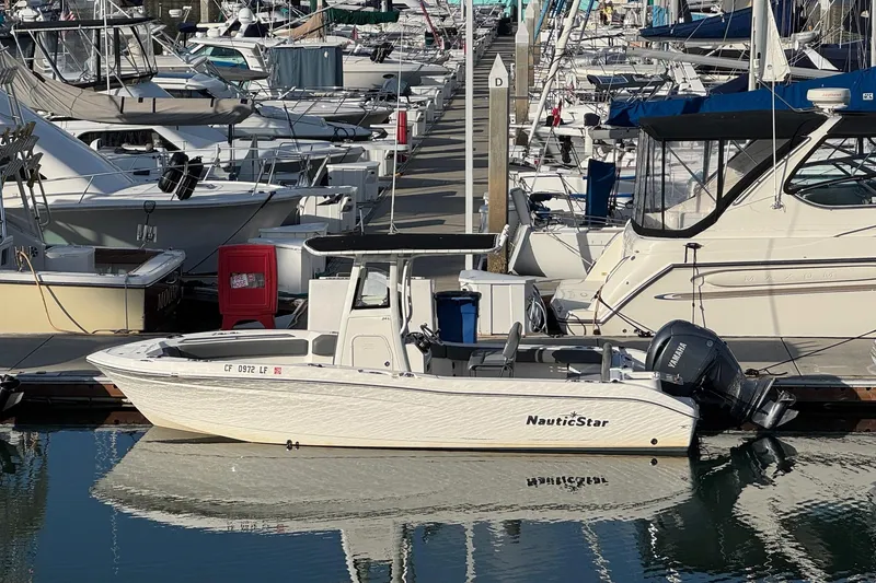 Slide: The Image of 2023 NauticStar 242L Offshore boat with gray seating and livewell at the dock. - 5
