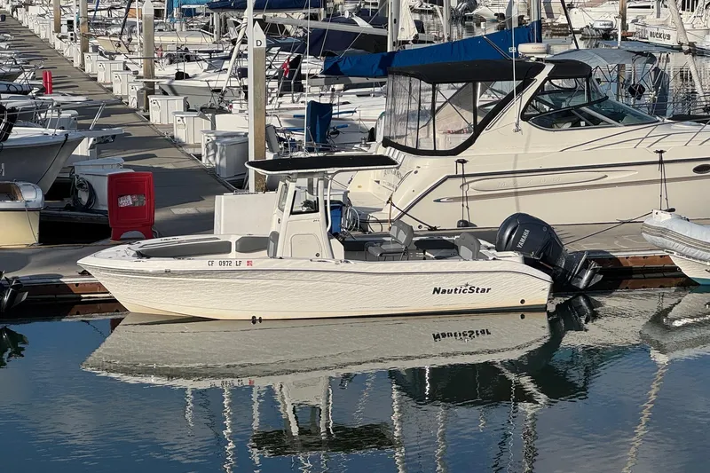 Slide: The Image of 2023 NauticStar 242L Offshore boat with Yamaha engine, featuring seating and cup holders. - 7