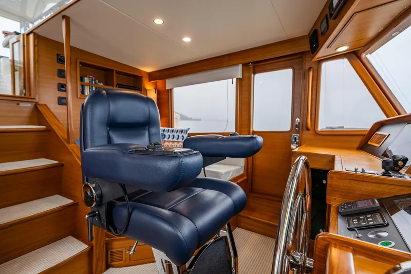 Slide: The Image of Luxurious 2026 Fleming 55 Pilothouse interior with plush captain's chair and wooden helm. - 36