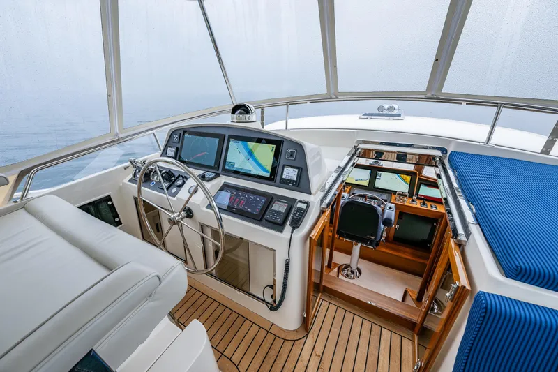 Slide: The Image of Pilothouse interior of 2026 Fleming 55 yacht with modern navigation equipment and wooden flooring. - 44