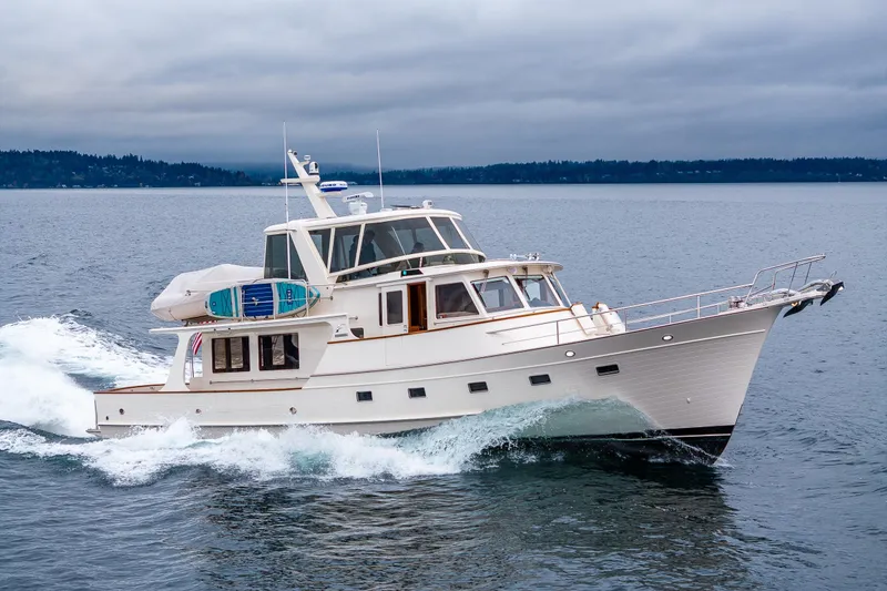 Slide: The Image of 2026 Fleming 55 Pilothouse yacht cruising on open water under cloudy skies. - 9