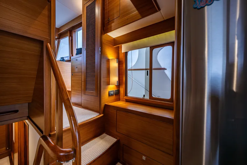 Slide: The Image of Luxurious interior of 2026 Fleming 55 Pilothouse yacht with wooden finishes and staircase. - 29