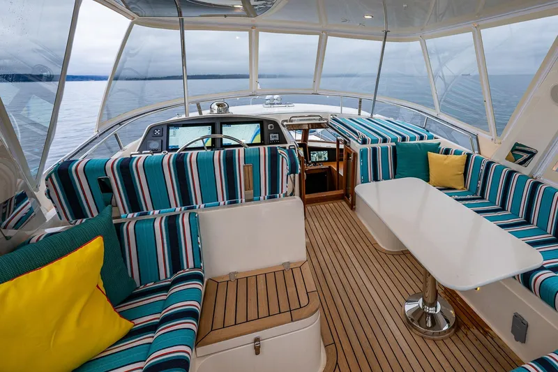 Slide: The Image of Luxurious 2026 Fleming 55 Pilothouse interior with striped seating and ocean view. - 44