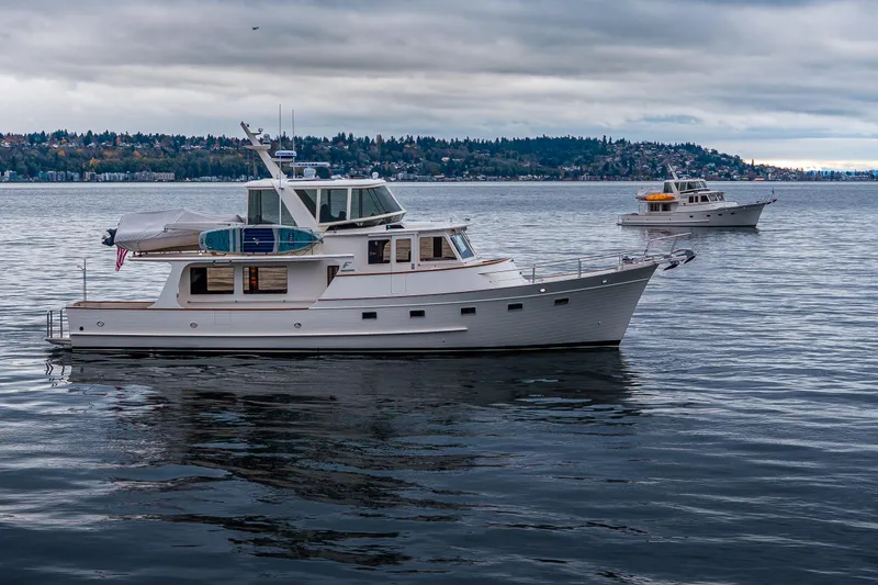 Slide: The Image of 2026 Fleming 55 Pilothouse yacht on calm water under cloudy sky. - 6