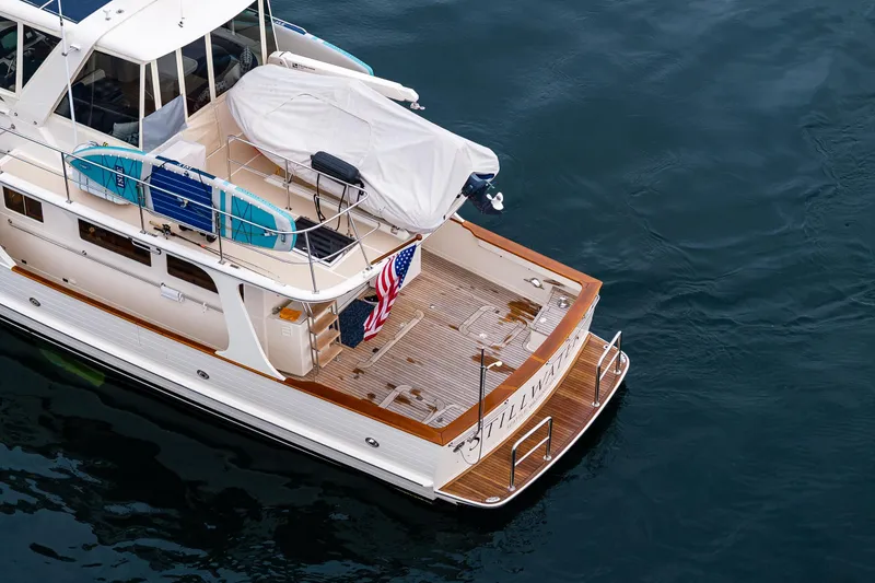 Slide: The Image of 2026 Fleming 55 Pilothouse yacht with surfboards and American flag on deck. - 13