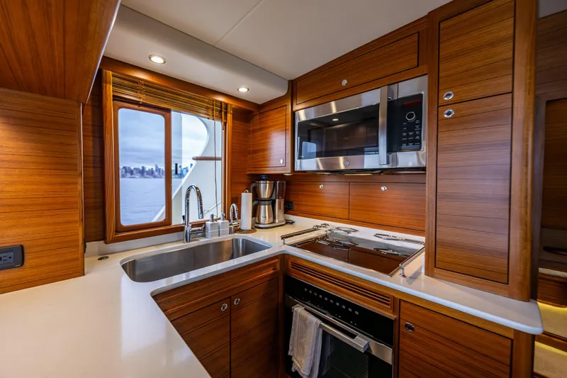 Slide: The Image of Luxurious kitchen interior of 2026 Fleming 55 Pilothouse yacht with modern appliances and wood finish. - 28