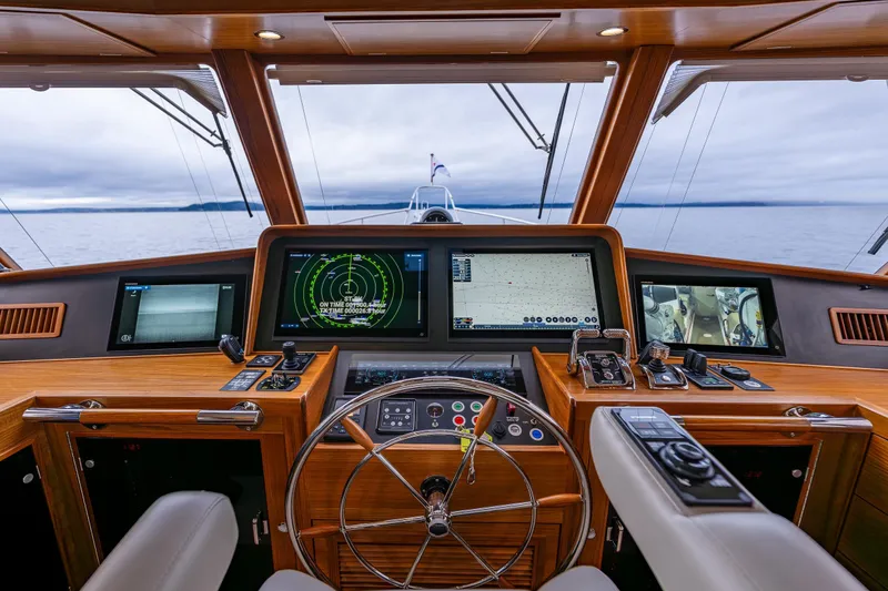 Slide: The Image of Pilothouse of 2026 Fleming 55 yacht with advanced navigation systems and wooden interior. - 33