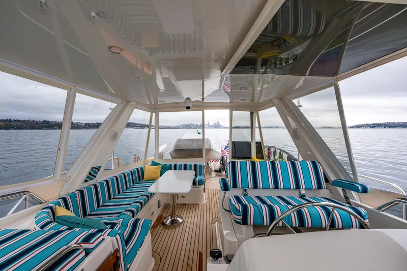 Slide: The Image of Luxurious 2026 Fleming 55 Pilothouse yacht interior with striped seating and scenic water view. - 42
