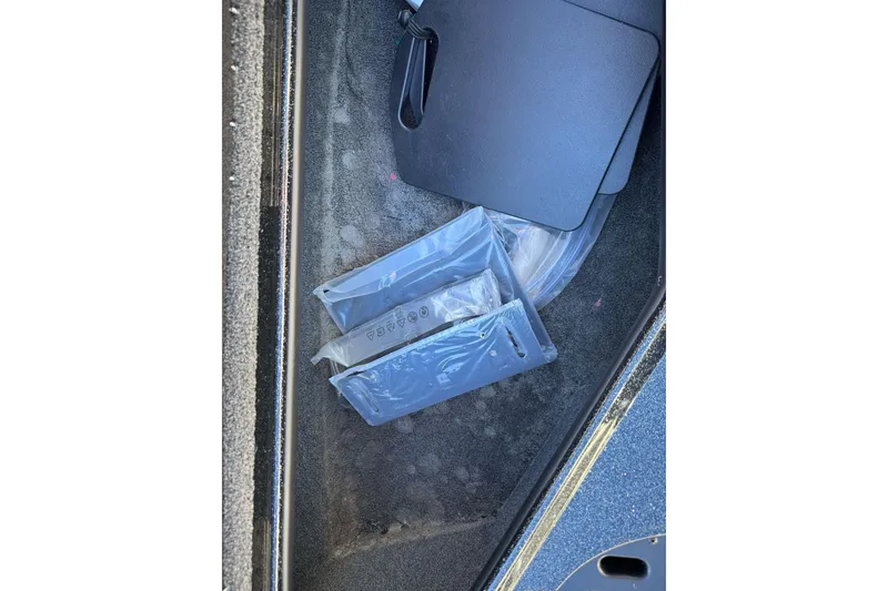 Slide: The Image of 2023 Nitro Z18 boat compartment with packaged accessories and black mat. - 14