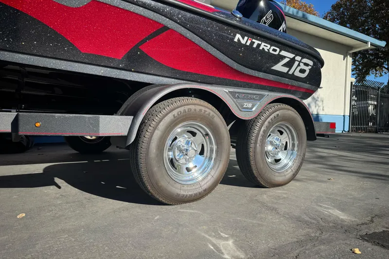 Slide: The Image of 2023 Nitro Z18 boat trailer with dual wheels, red and black design. - 2