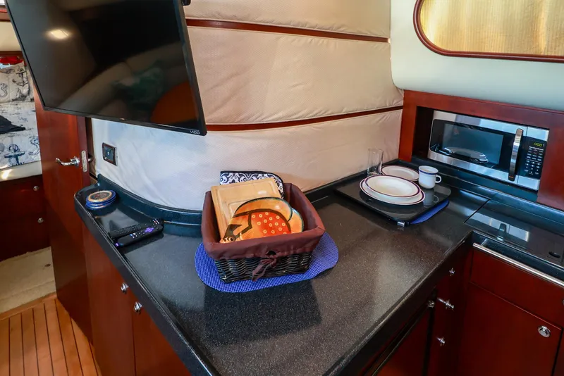 Slide: The Image of 2004 Chris-Craft Roamer 40 yacht interior with kitchen counter, microwave, and TV. - 20