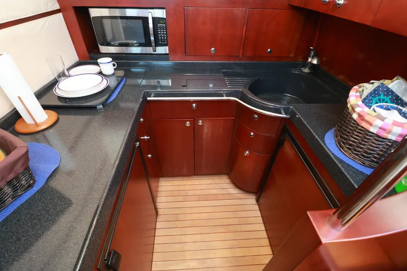 Slide: The Image of Luxurious 2004 Chris-Craft Roamer 40 yacht kitchen with wood cabinetry and modern appliances. - 21