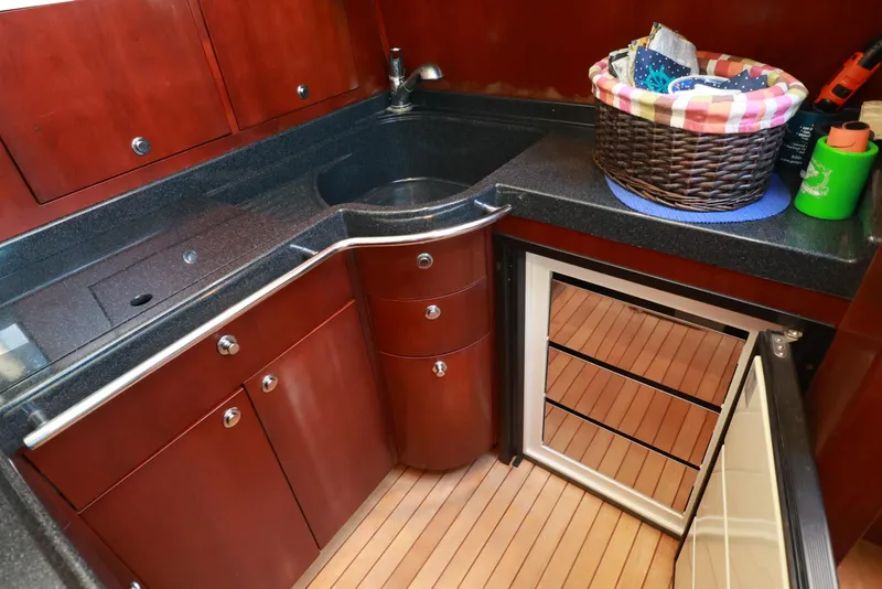 Slide: The Image of Luxurious 2004 Chris-Craft Roamer 40 yacht kitchen with wood cabinetry and modern appliances. - 22