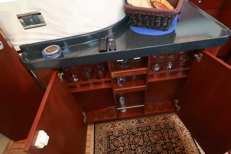 Slide: The Image of Interior of 2004 Chris-Craft Roamer 40 yacht with open cabinets and countertop accessories. - 23