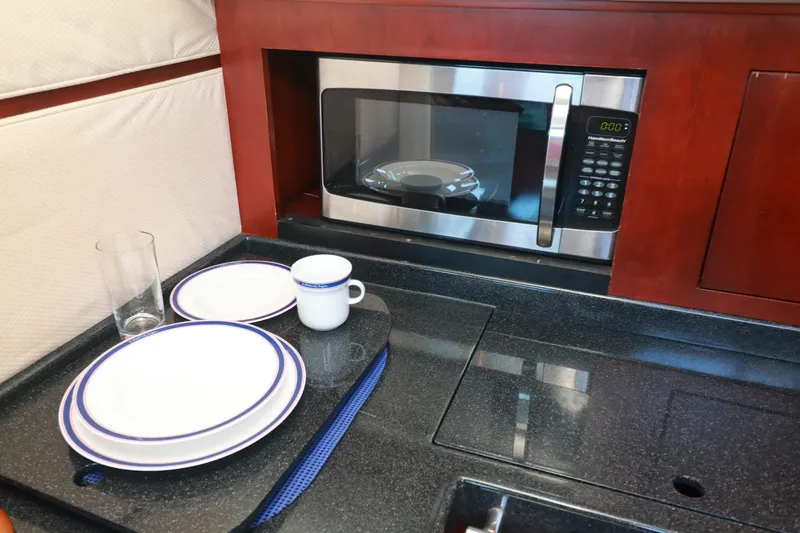 Slide: The Image of Galley kitchen in 2004 Chris-Craft Roamer 40 with microwave and dishware. - 24