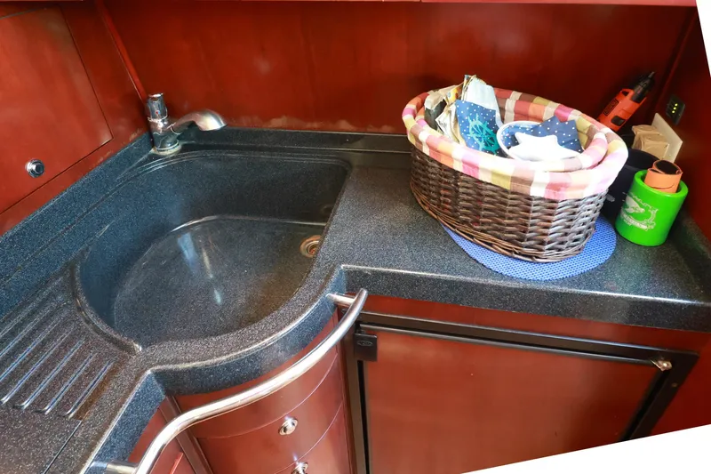 Slide: The Image of 2004 Chris-Craft Roamer 40 kitchen sink area with basket and countertop accessories. - 27