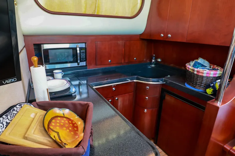 Slide: The Image of Luxurious 2004 Chris-Craft Roamer 40 yacht kitchen with wood cabinetry and modern appliances. - 29