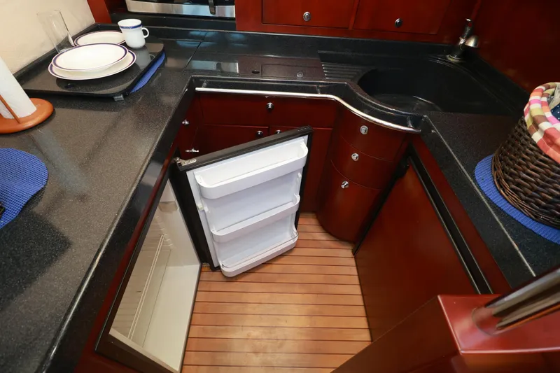 Slide: The Image of Luxurious kitchen area in 2004 Chris-Craft Roamer 40 yacht with open fridge and wooden flooring. - 30