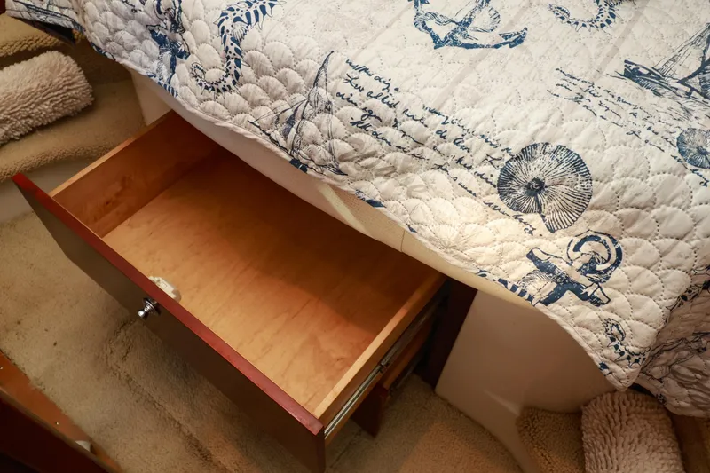Slide: The Image of Open wooden drawer under nautical-themed quilt on Chris-Craft Roamer 40, 2004 model. - 37