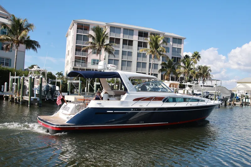 Slide: The Image of 2004 Chris-Craft Roamer 40 yacht cruising near waterfront buildings and palm trees. - 4