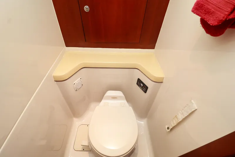 Slide: The Image of 2004 Chris-Craft Roamer 40 yacht bathroom with toilet and wooden cabinet. - 41