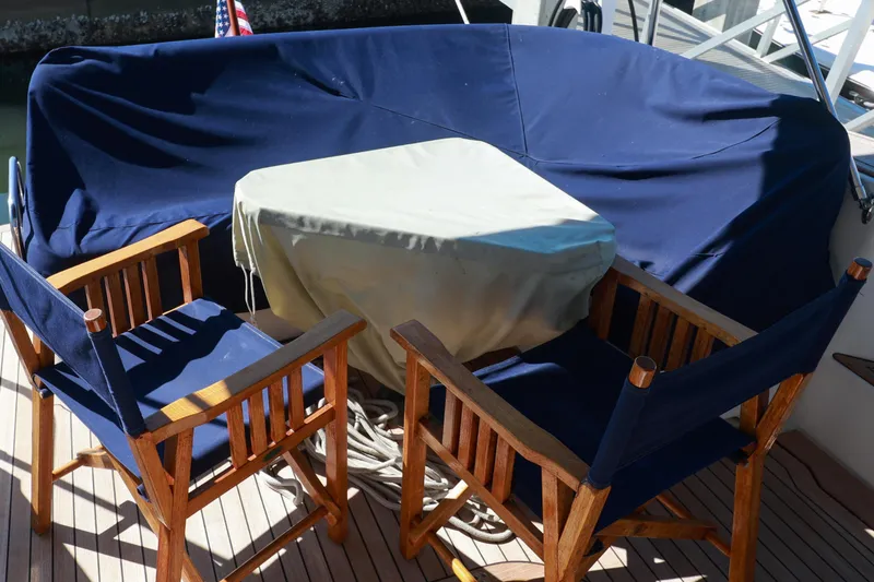 Slide: The Image of Outdoor seating area on 2004 Chris-Craft Roamer 40 yacht with wooden chairs and covered table. - 59
