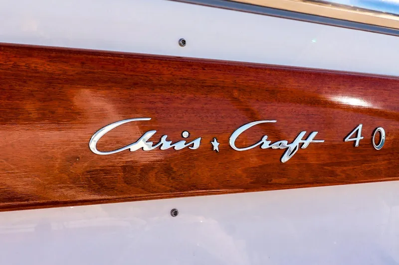 Slide: The Image of 2004 Chris-Craft Roamer 40 boat logo on polished wood panel. - 9