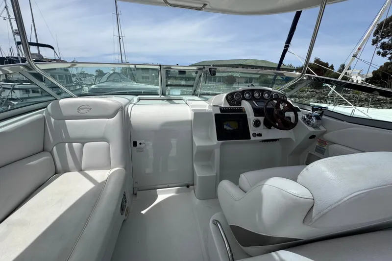 Slide: The Image of 2008 Crownline 340 CR boat cockpit with white seating and modern dashboard controls. - 9