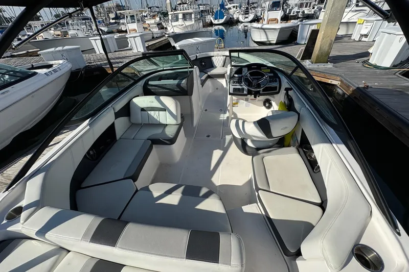 Slide: The Image of 2024 Regal 21 OBX boat interior with spacious seating and modern dashboard at marina. - 10