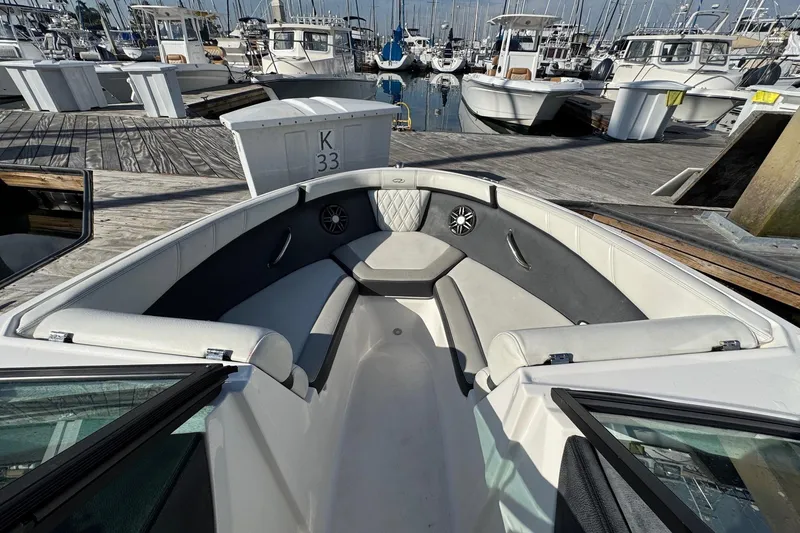 Slide: The Image of 2024 Regal 21 OBX boat interior at marina, featuring spacious seating and modern design. - 21