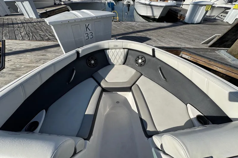 Slide: The Image of 2024 Regal 21 OBX boat interior with cushioned seating and speakers at a dock. - 22