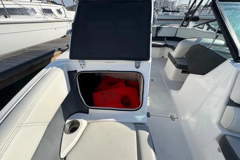 Slide: The Image of 2024 Regal 21 OBX boat interior with open storage compartment and life jackets. - 23