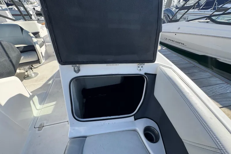 Slide: The Image of 2024 Regal 21 OBX boat interior with open storage compartment and seating. - 24