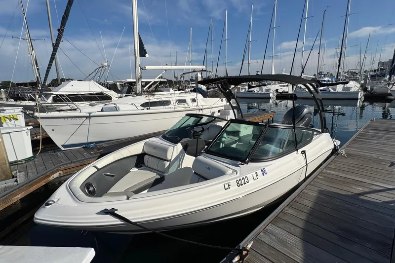 Slide: The Image of 2024 Regal 21 OBX boat docked at a marina with sailboats in the background. - 7