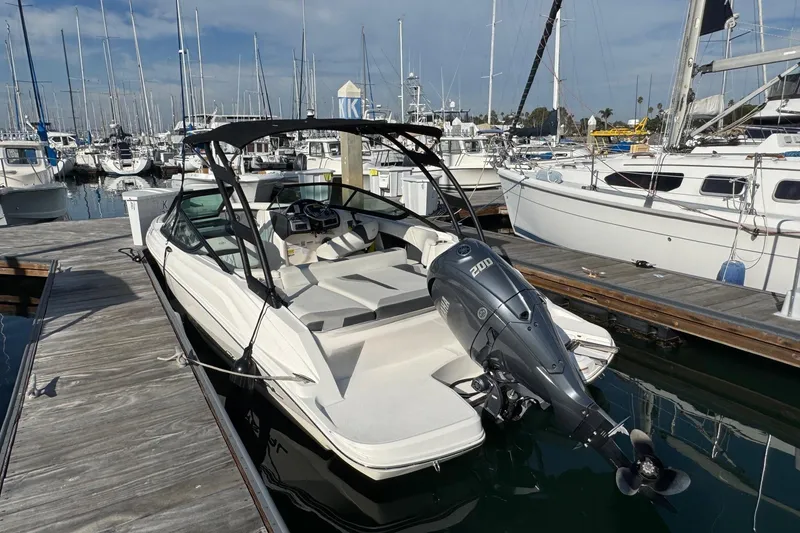 Slide: The Image of 2024 Regal 21 OBX boat docked at marina, featuring sleek design and powerful outboard motor. - 8