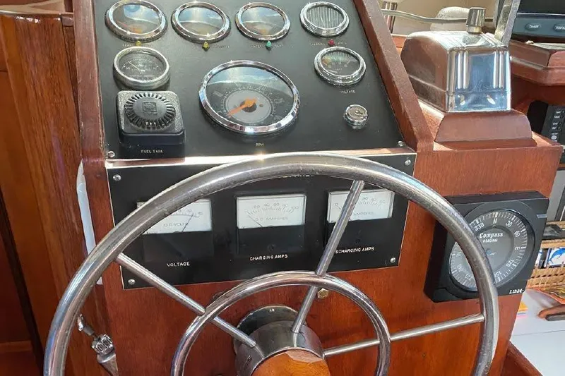 Slide: The Image of 1977 Dufour CT 12000 yacht helm with gauges, compass, and wooden finish. - 10