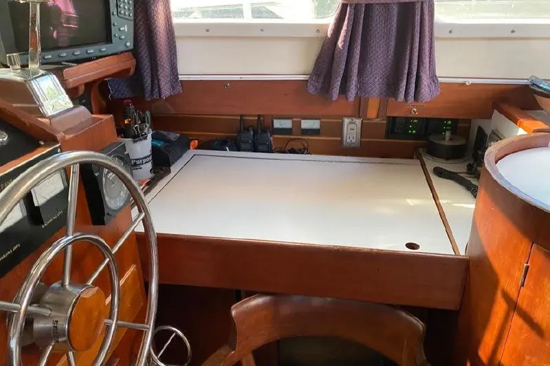 Slide: The Image of Interior of 1977 Dufour CT 12000 sailboat with navigation station and steering wheel. - 11