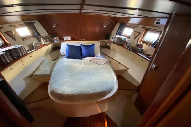 Slide: The Image of Cozy cabin interior of 1977 Dufour CT 12000 yacht with bed and wooden decor. - 17