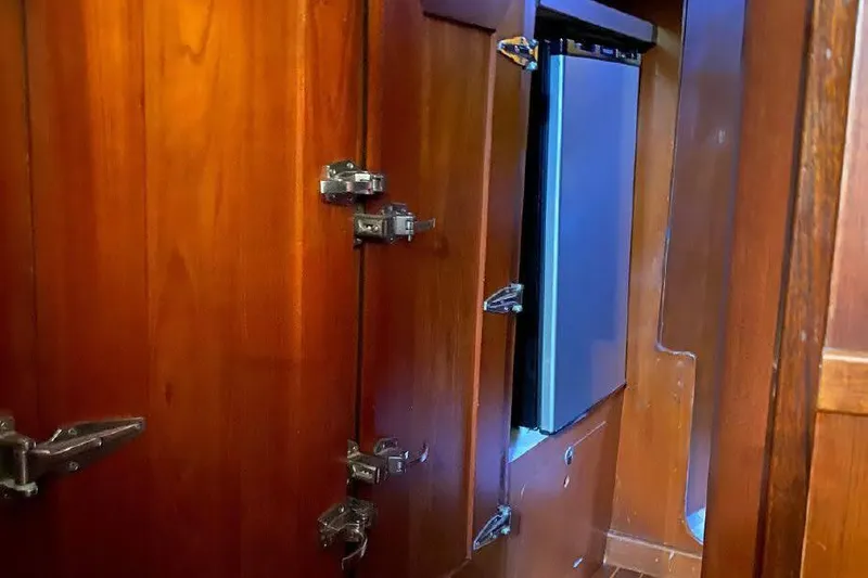 Slide: The Image of Interior of 1977 Dufour CT 12000 yacht with wooden cabinetry and metal hinges. - 18