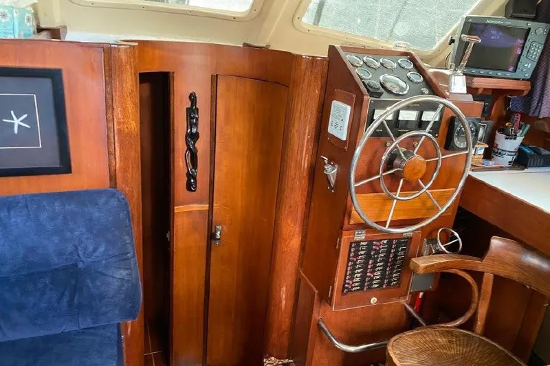 Slide: The Image of 1977 Dufour CT 12000 yacht interior with wooden helm and navigation equipment. - 21