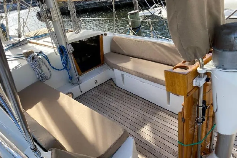 Slide: The Image of 1977 Dufour CT 12000 sailboat cockpit with cushioned seating and nautical ropes. - 3