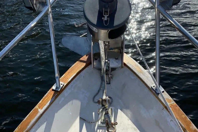 Slide: The Image of Bow of 1977 Dufour CT 12000 sailboat with anchor, on sparkling water. - 7