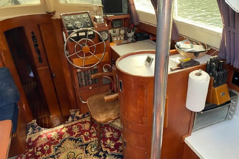Slide: The Image of Interior of a 1977 Dufour CT 12000 boat with wooden helm and nautical instruments. - 8