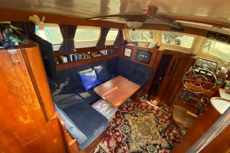 Slide: The Image of Cozy interior of 1977 Dufour CT 12000 sailboat with wooden furnishings and nautical decor. - 9