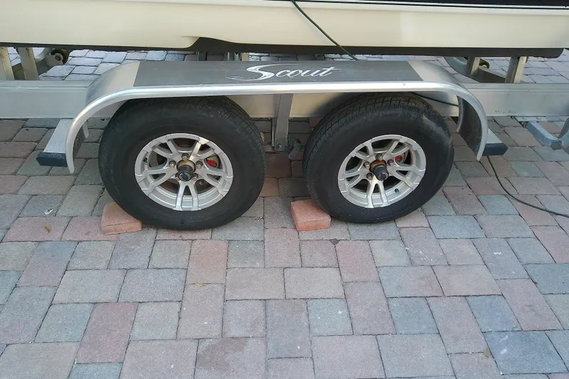 Slide: The Image of Trailer wheels of a 2018 Scout 251 XSS boat on brick pavement. - 17