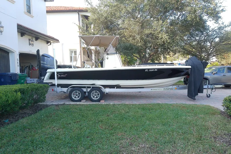 Slide: The Image of 2018 Scout 251 XSS boat on trailer parked in residential driveway. - 2