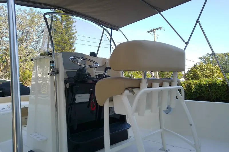 Slide: The Image of 2018 Scout 251 XSS boat interior with helm and seating under canopy. - 23